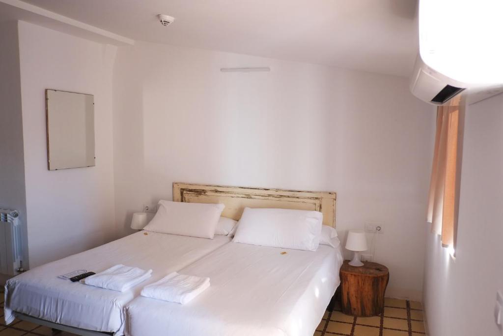 塔拉戈纳皮加尔酒店的卧室配有白色的床和2个枕头