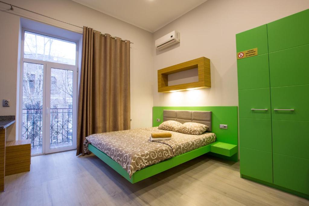 哈尔科夫Pushkinskaya Apartments的绿色卧室设有床和窗户