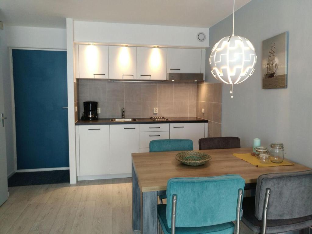 霍勒姆Zeebries in De Kaap 4 p的厨房配有木桌和蓝色椅子