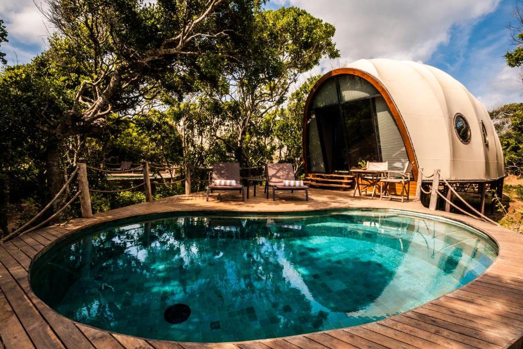 雅拉Wild Coast Tented Lodge All Inclusive的圆顶房屋设有游泳池和天井