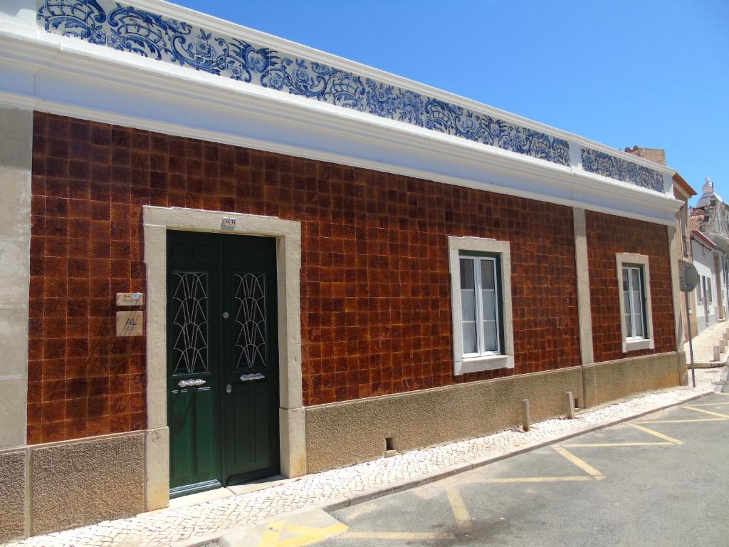 拉戈斯Casa Flor do Mar Lagos的红砖建筑,设有绿门