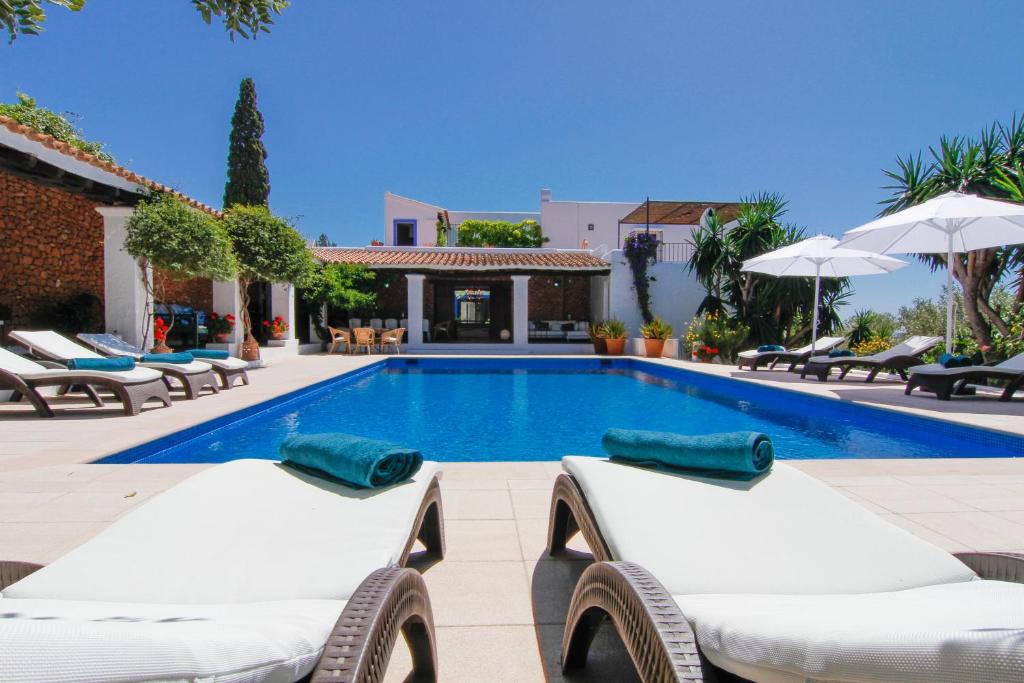 Puig D’en VallsBab el Oued Villa Ibiza的一个带躺椅的游泳池以及别墅
