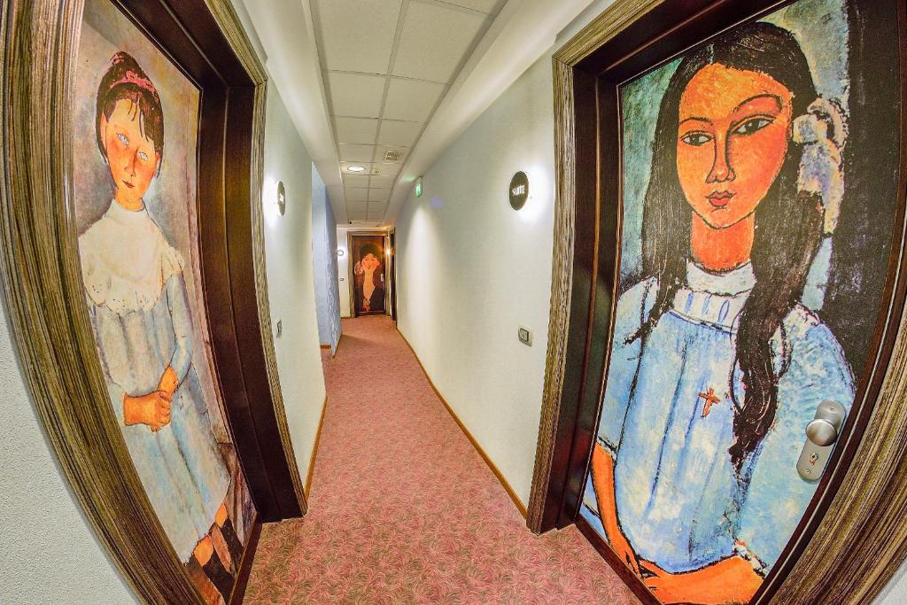 佩斯卡拉维多利亚酒店的墙上挂有妇女画的走廊