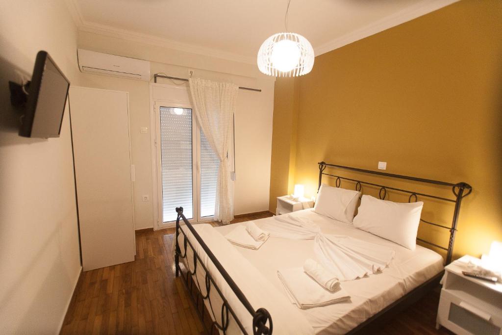 雅典Athens City Themis 3的一间卧室配有一张带白色床单的床和一扇窗户。