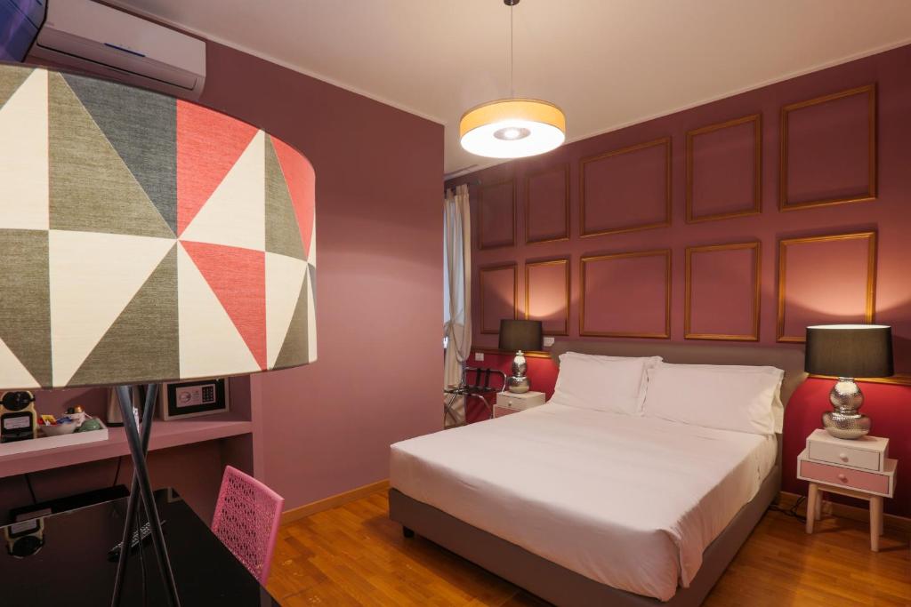 罗马DEM旅馆的一间卧室配有一张大床和一盏灯