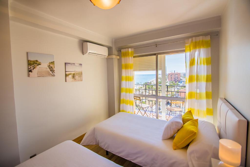 马拉加Piso primera línea de playa的一间卧室设有一张床和一个美景窗户。