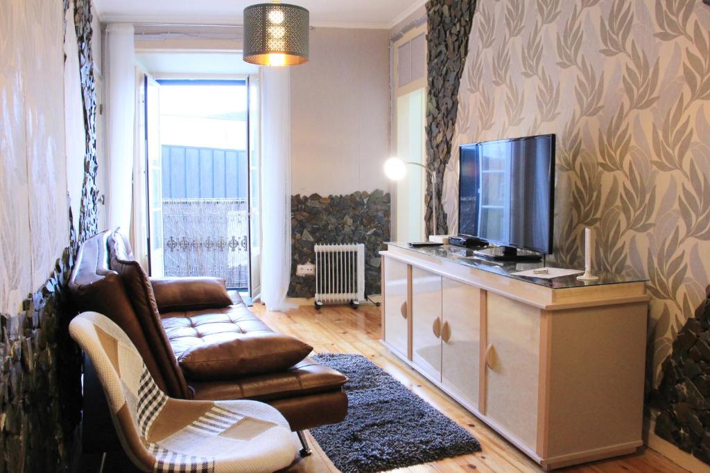 里斯本卡萨贝卡公寓的客厅配有电视、沙发和椅子