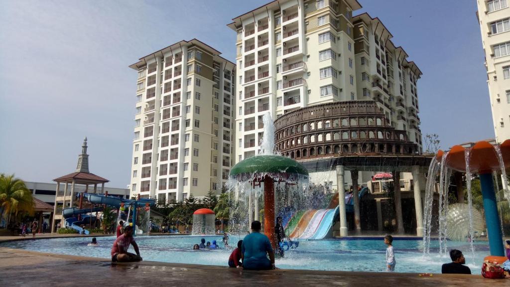 马六甲CT Homestay at Lagoon Park Resort的一群人坐在水上公园周围