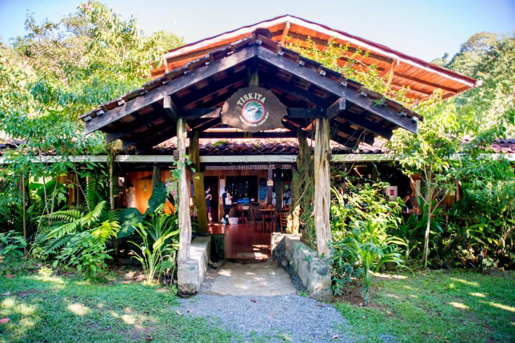 帕沃内斯Tiskita Jungle Lodge的花园中一座带木屋顶的建筑