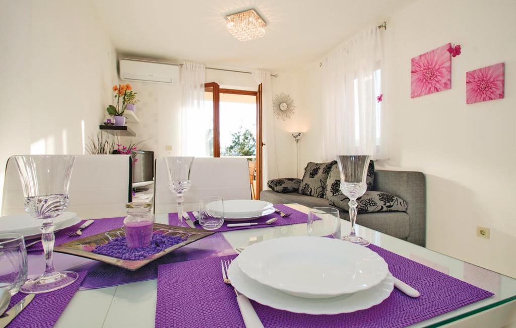 拉巴克Apartment Rosana的紫色桌布上带盘子和眼镜的桌子