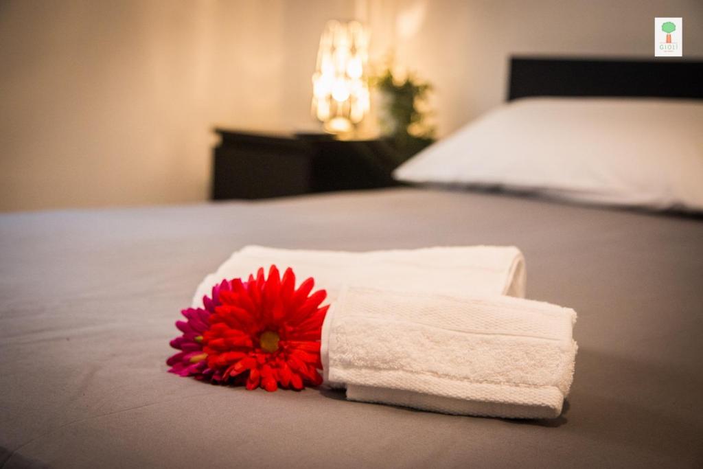 滨海波利尼亚诺Giolì的床上有一大堆毛巾和一朵红花