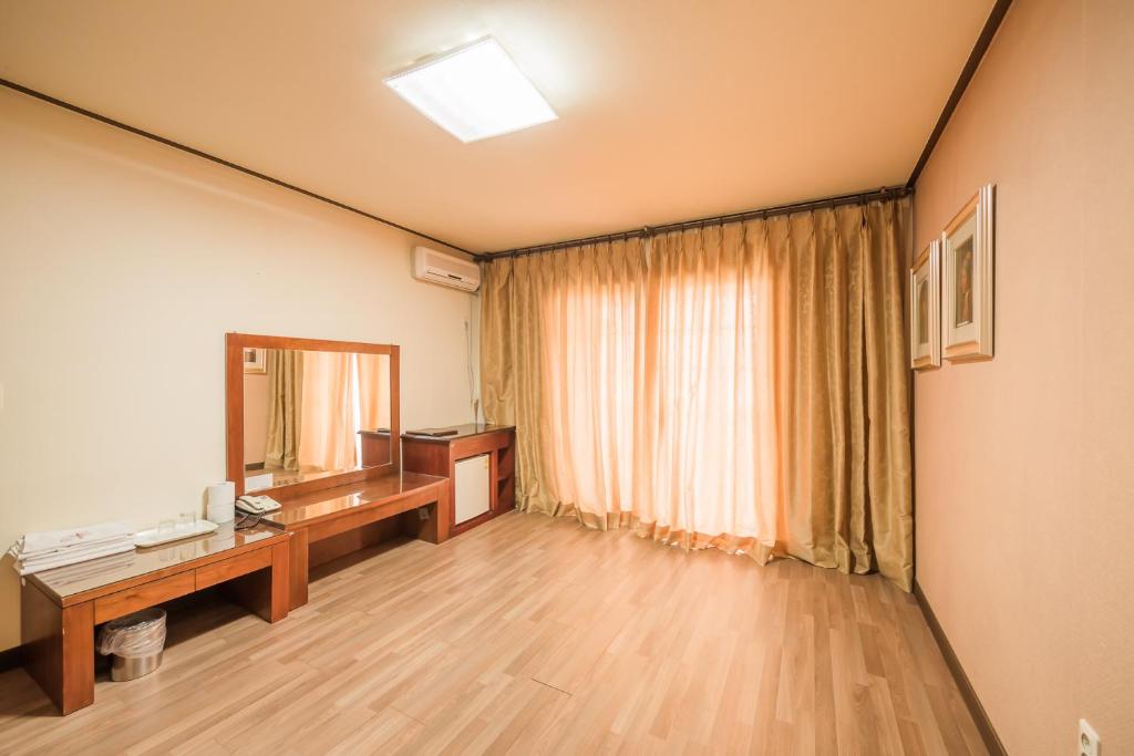 郁陵迪乌隆度假村的客房设有书桌和镜子