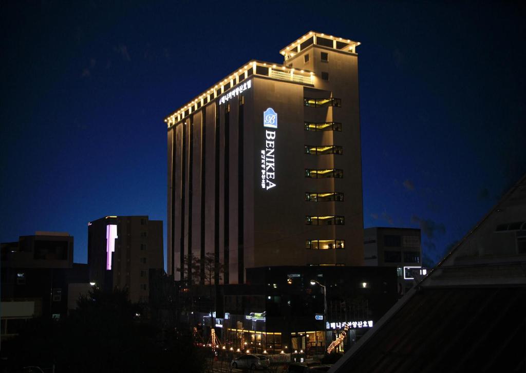 Yangsan梁山本尼科亚酒店的一座高大的建筑,晚上有标志