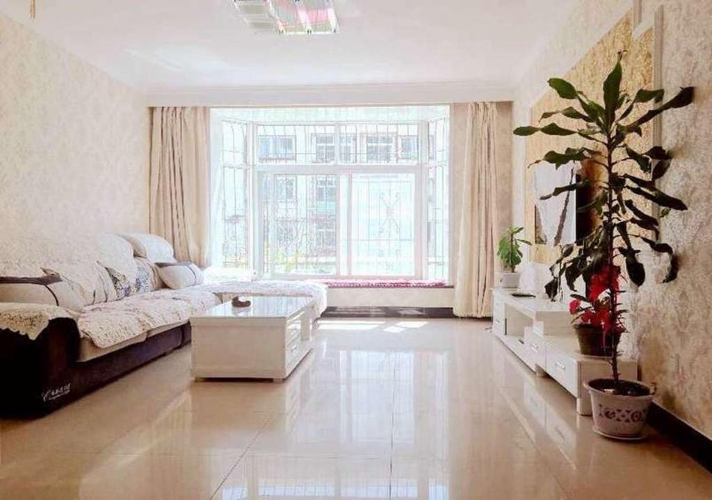 秦皇岛北戴河海之恋假日公寓的带沙发和大窗户的客厅