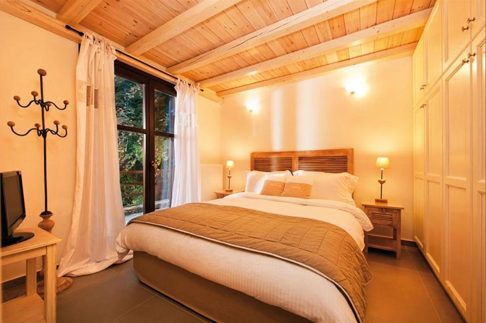 莫雷逊Vergopoulos Oliveyard的一间卧室设有一张大床和一个窗户。