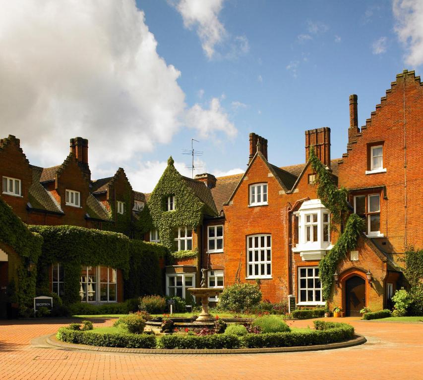 诺里奇Sprowston Manor Hotel, Golf & Country Club的一座带庭院的大型红砖建筑