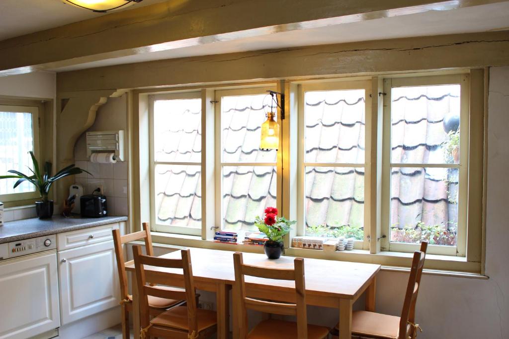 阿姆斯特丹Amsterdam Central Guest House的厨房配有木桌和四扇窗户。