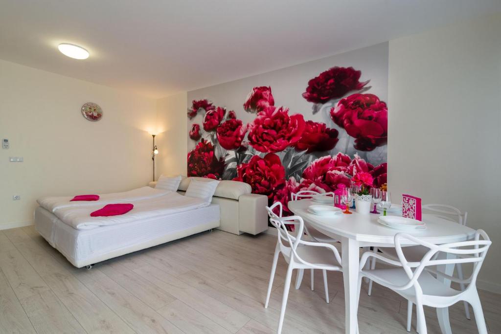 金沙Sea Star Kabakum Apartments的一间卧室配有一张床铺和一张桌子,并拥有红色玫瑰壁画