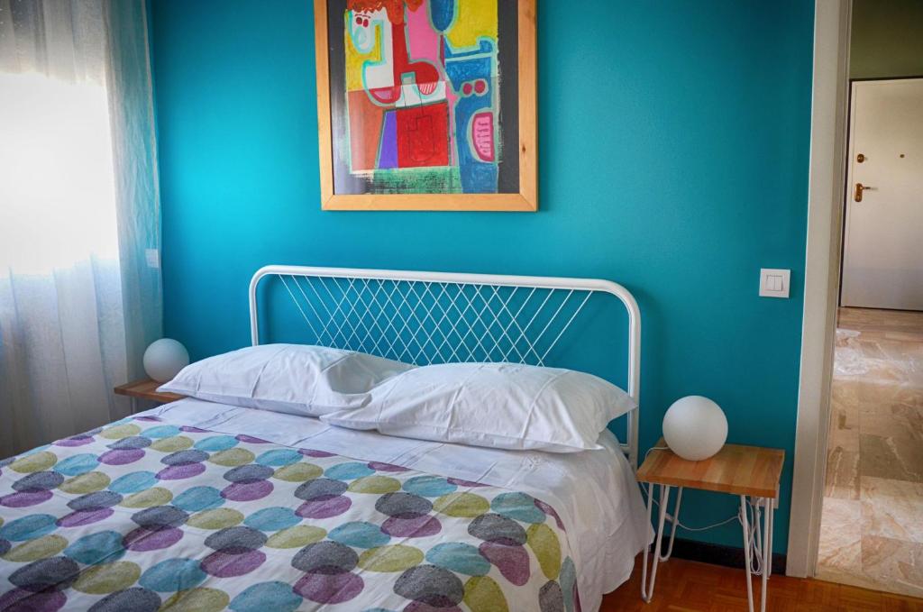 米兰Tortona86的一间蓝色的卧室,配有一张床和墙上的绘画