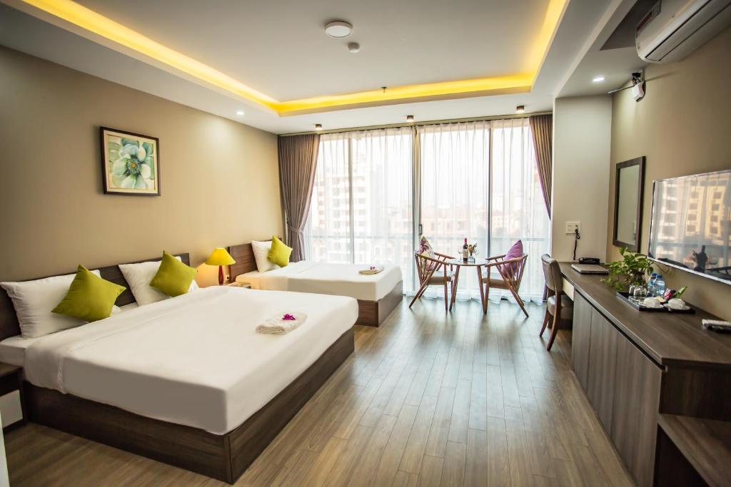 北宁Hana 2 Apartment & Hotel Bac Ninh的酒店客房配有一张床铺和一张桌子。