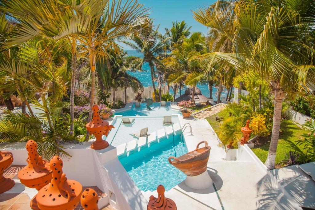 圣克鲁斯华特库Villas Fasol Huatulco的一个带游泳池和棕榈树的度假村