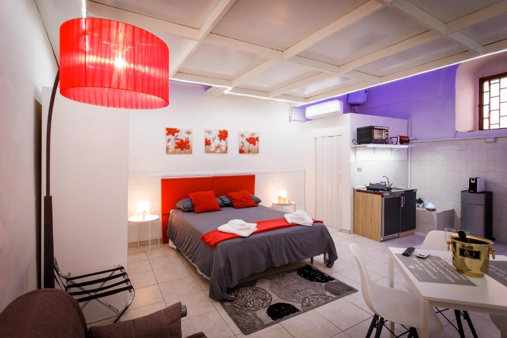 切里尼奥拉B&B La Casetta的一间卧室配有一张带红色枕头的床和一张桌子