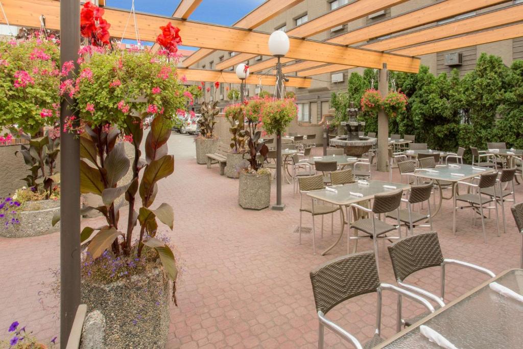 基洛纳基洛纳华美达会议中心酒店的户外庭院设有桌椅和鲜花