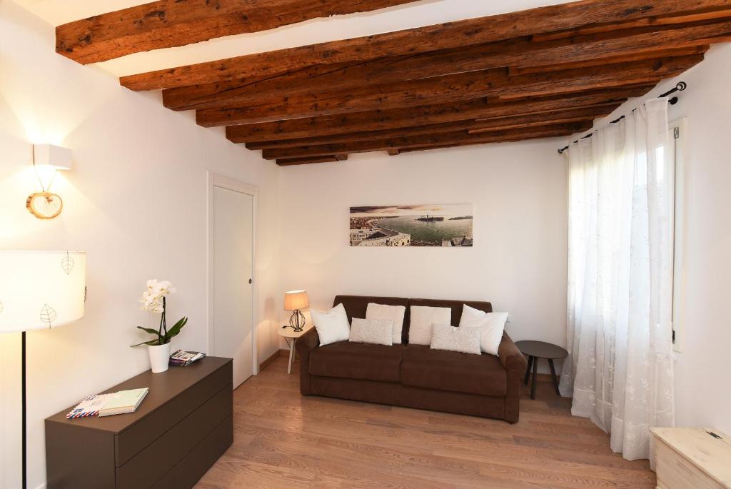 威尼斯homesweethome venice的带沙发和木制天花板的客厅