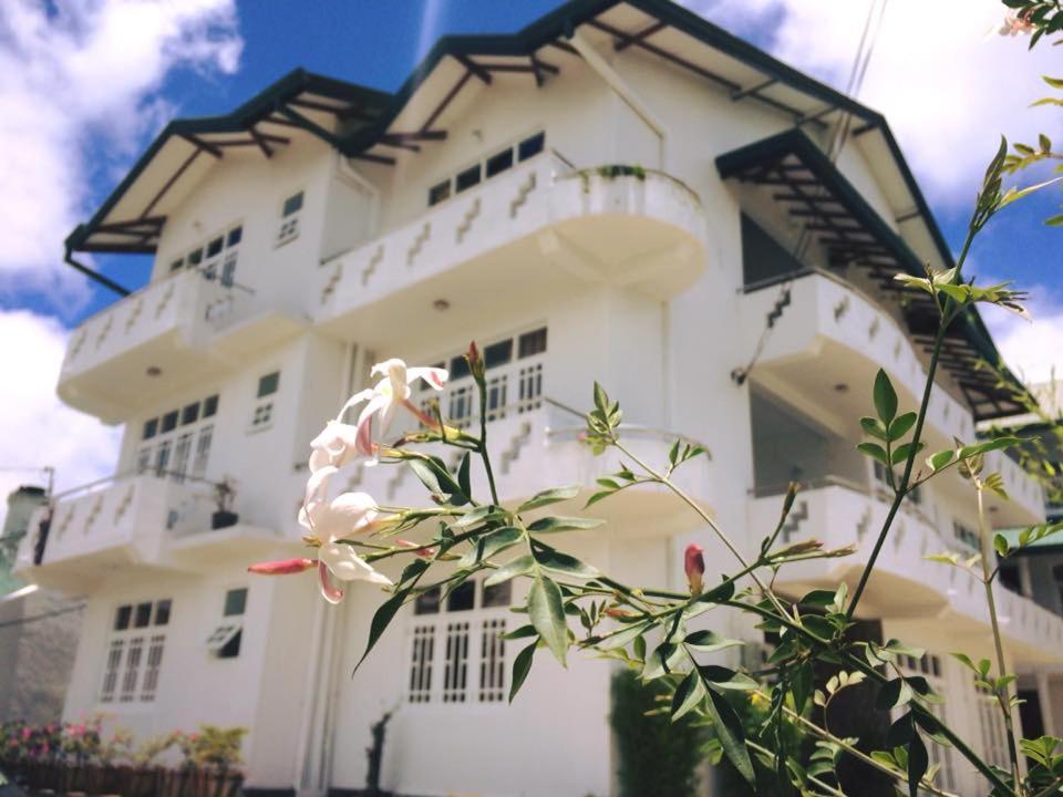 努沃勒埃利耶湖景私人酒店的前面有花的白色建筑