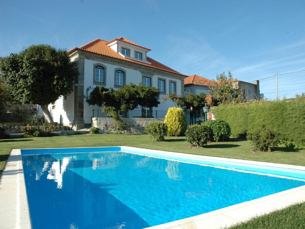 Santa Marinha do Zêzere金塔大卡萨格兰德皮涅罗乡村民宿的房子前面的蓝色游泳池