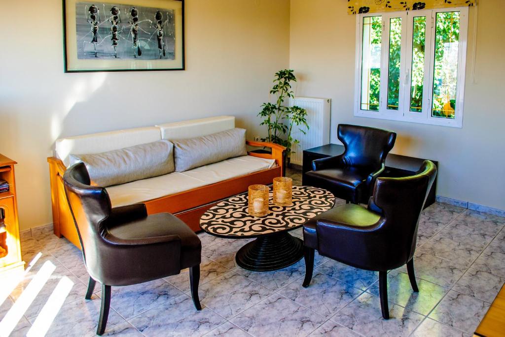 ValsamátaPanochori Apartment的客厅配有沙发、两把椅子和一张桌子