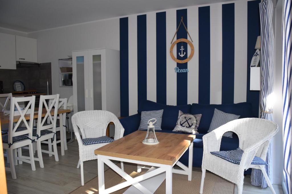波别罗沃Dom w Pobierowie的一间配备有蓝色沙发和白色椅子的用餐室