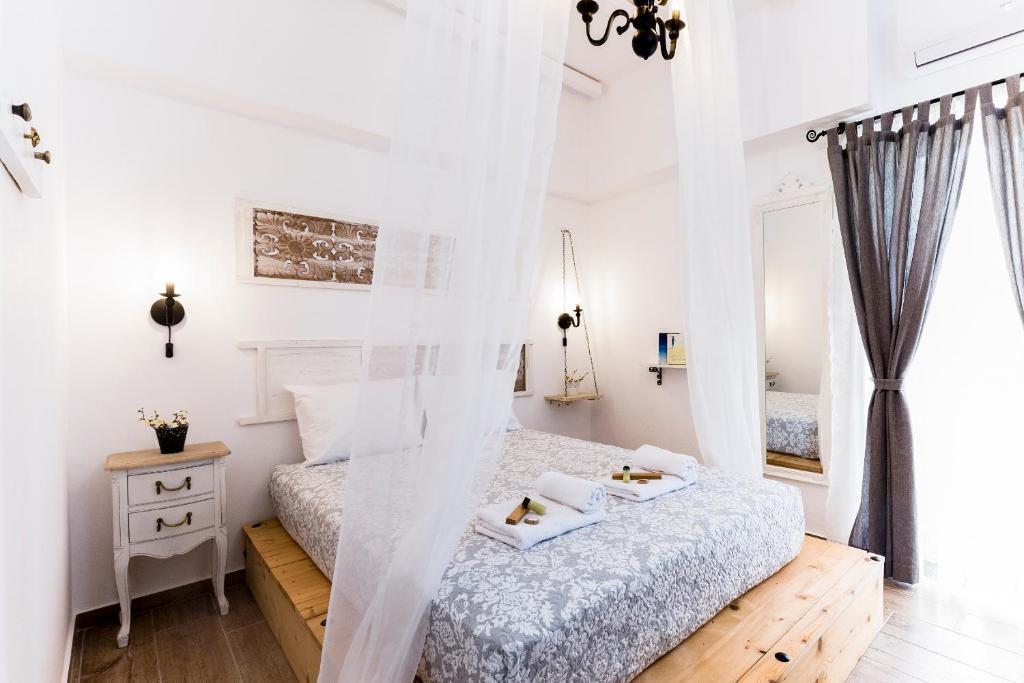 基萨莫斯EvaEle Luxury Apartments的卧室拥有白色的墙壁和白色床单。