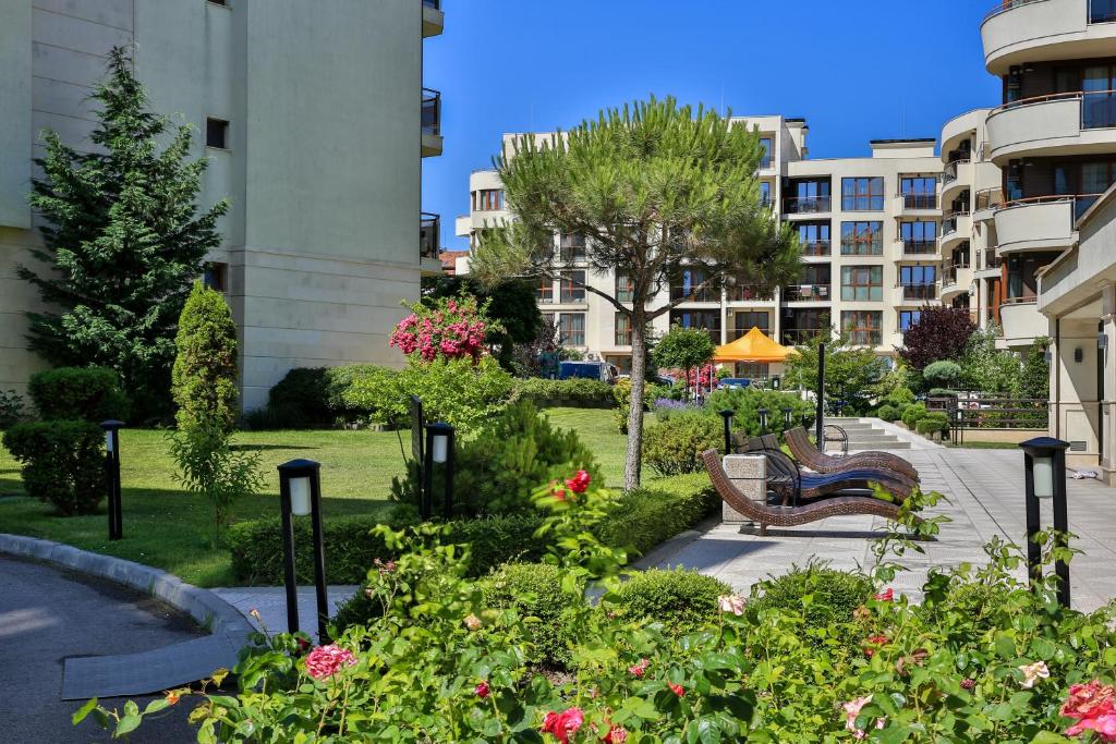 希科尔皮诺夫西Al Rial Beach Apartments的建筑前有长椅和鲜花的公园