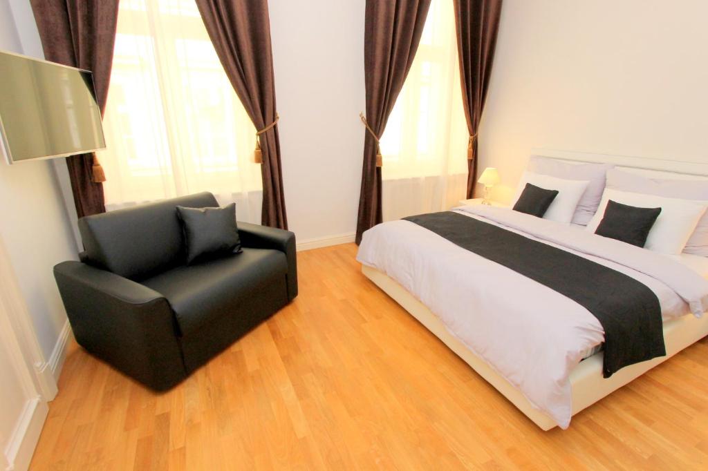 布拉格Luxury apartments Krocínova的一间卧室配有一张床和一张黑椅