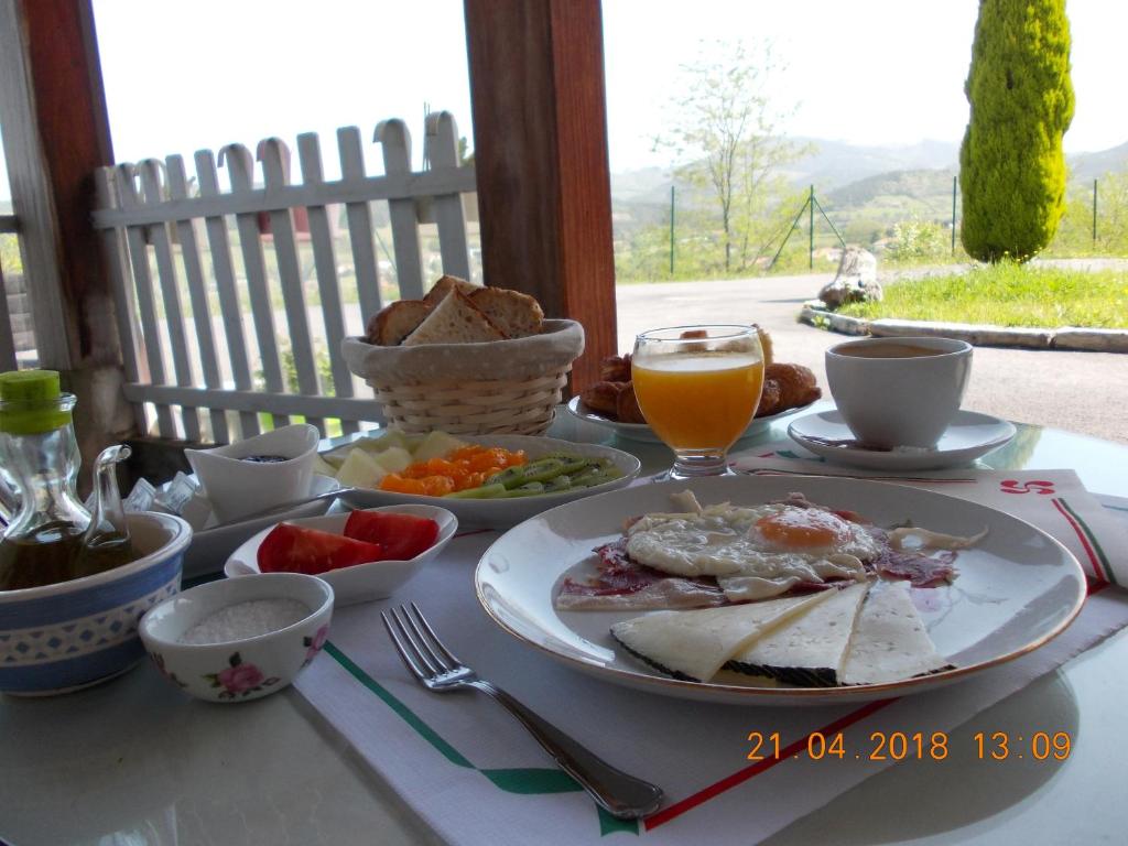 Larrabetzu米亚门地卡萨乡村酒店的一张早餐桌,上面有一盘食物和一杯橙汁