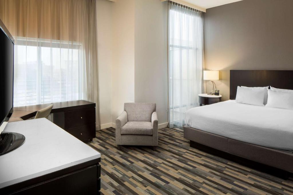 夏洛特悦府夏洛特中心城酒店的配有一张床和一把椅子的酒店客房