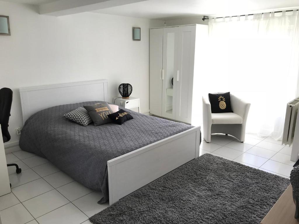 BretenièreApartment 36 m²的白色卧室配有床和椅子