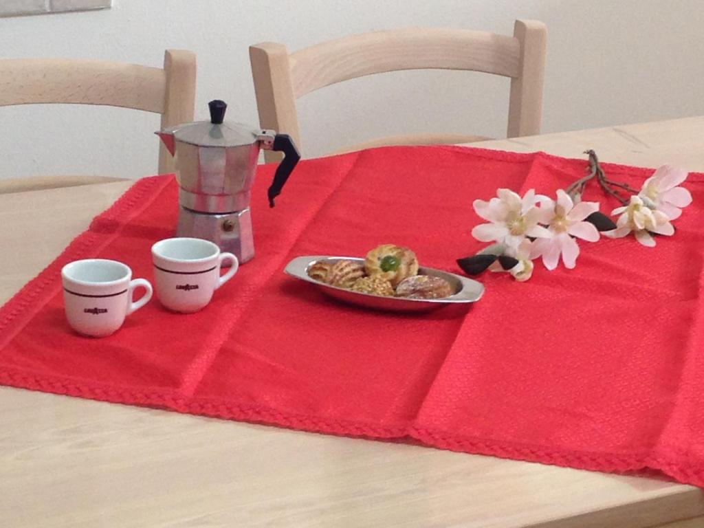 MiggianoCasa-Lisa seminterrato的一张桌子,上面放着两杯,还有一盘食物,放在红色餐巾纸上