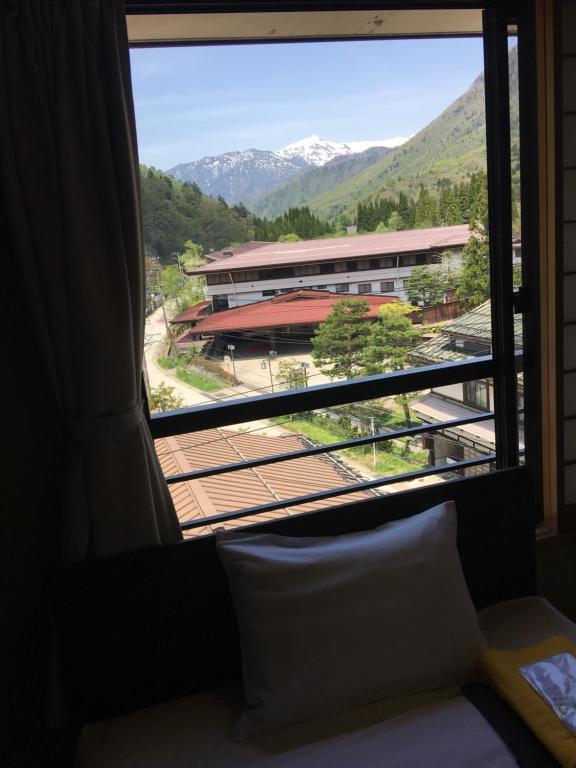 高山黑拉尤诺莫利酒店的窗户享有建筑和山脉的景致。
