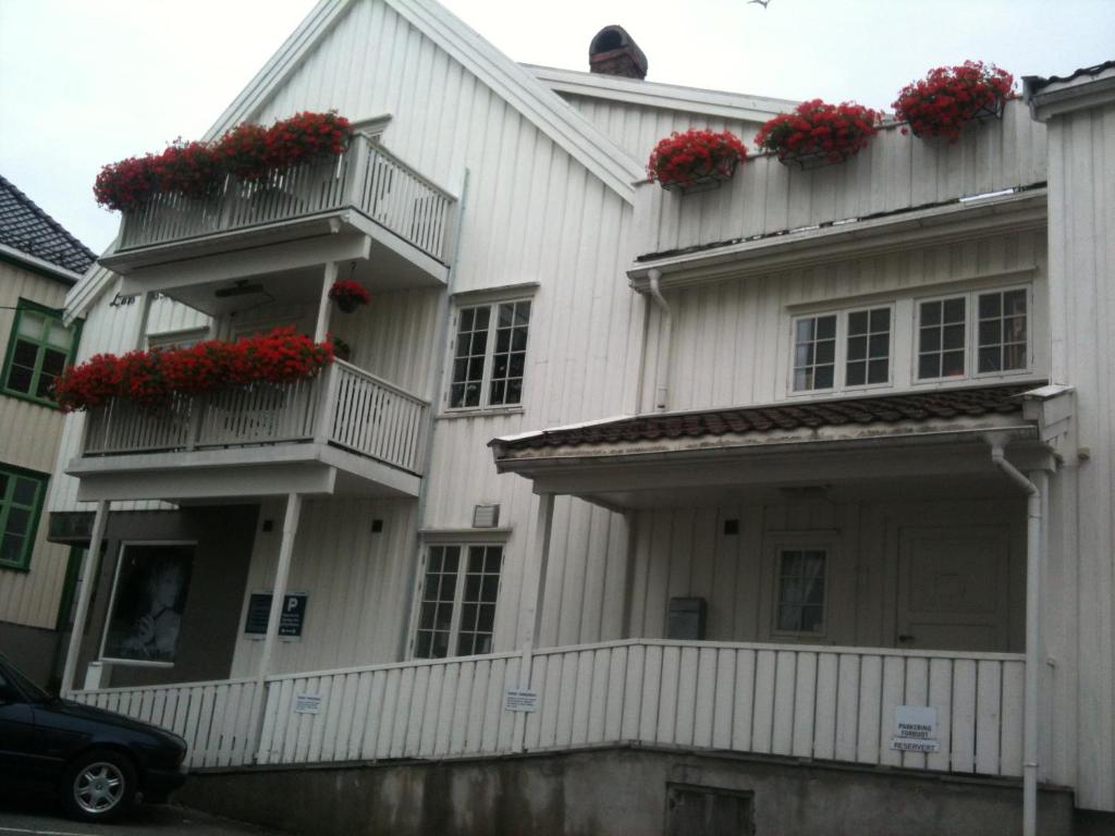 格里姆斯塔Holsthuset Losji的阳台上的白色房子,有红色的鲜花
