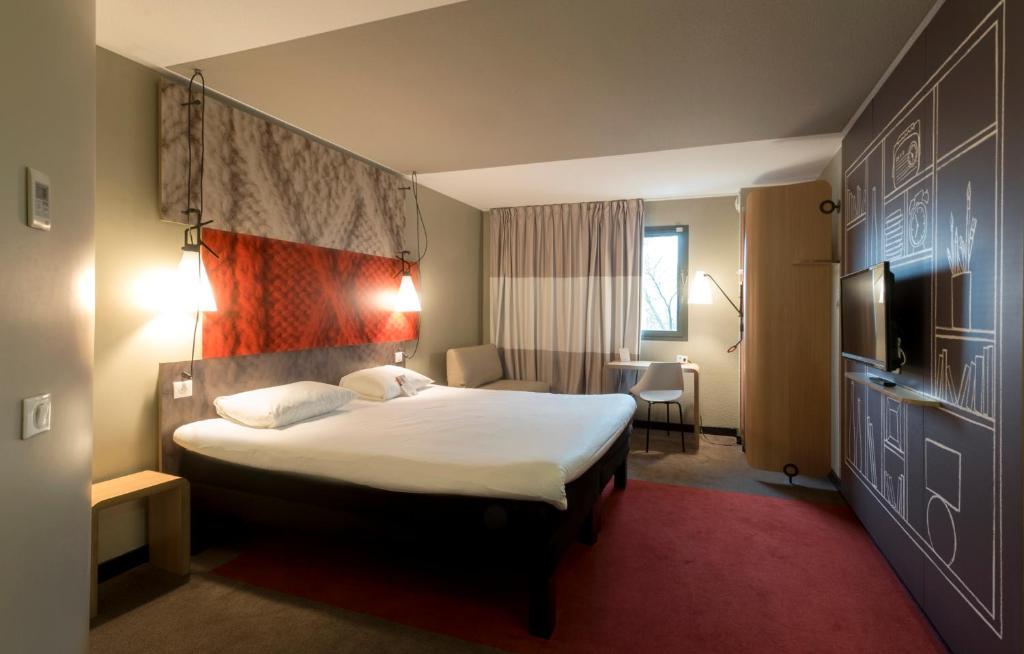 鲁昂ibis Rouen Centre Champ de Mars的一间酒店客房,配有一张床和一台电视