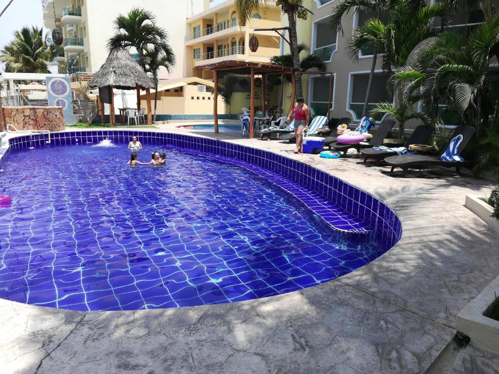 曼萨尼约埃斯孔迪多酒店的一名在蓝色瓷砖游泳池玩耍的儿童