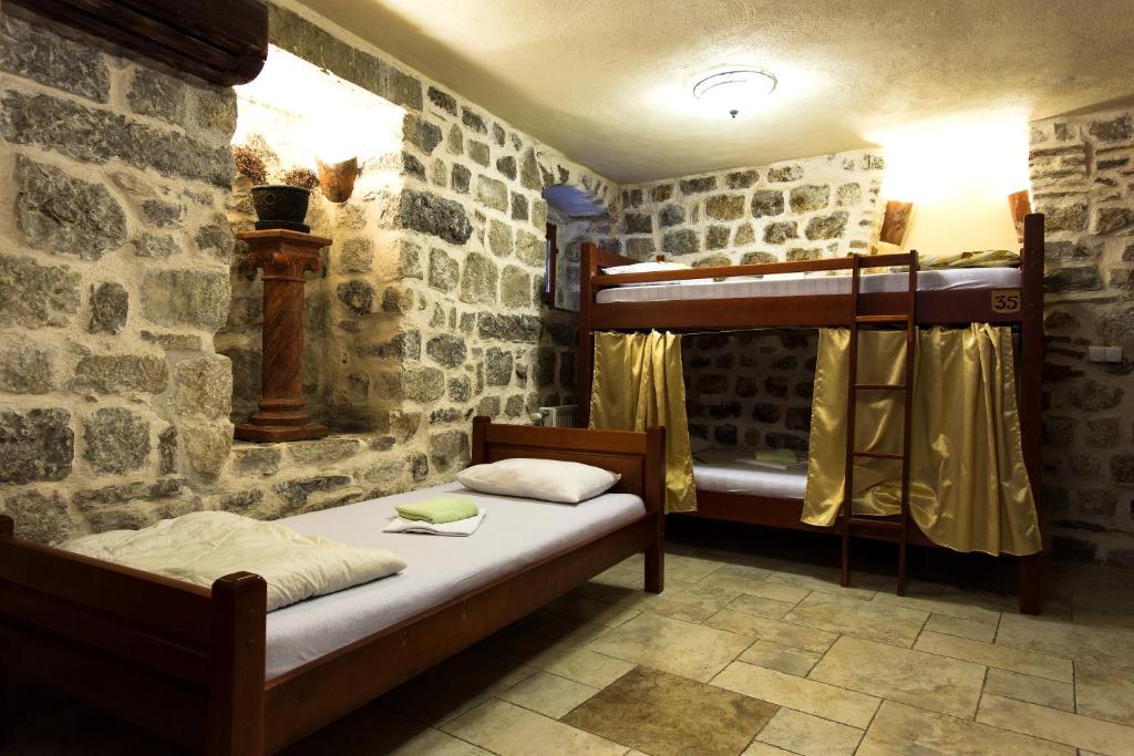 科托尔老城青年旅舍的一间卧室设有石墙内的两张双层床。