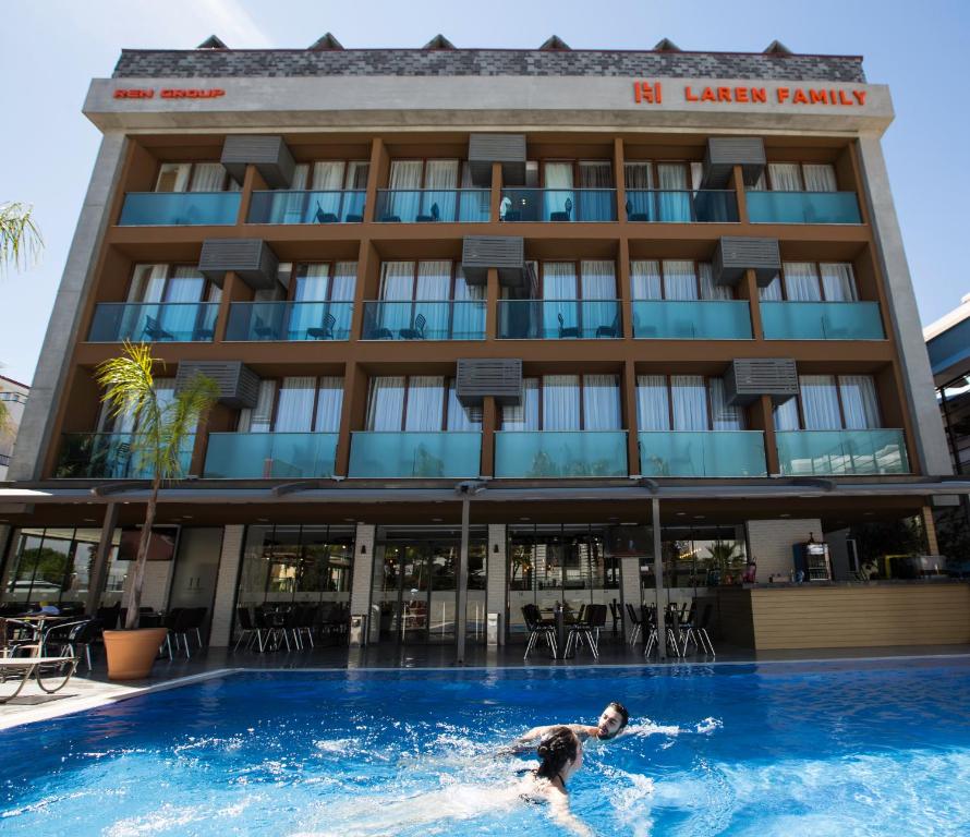 安塔利亚拉仁家庭Spa酒店 - 精品级的一个人在酒店前的游泳池游泳