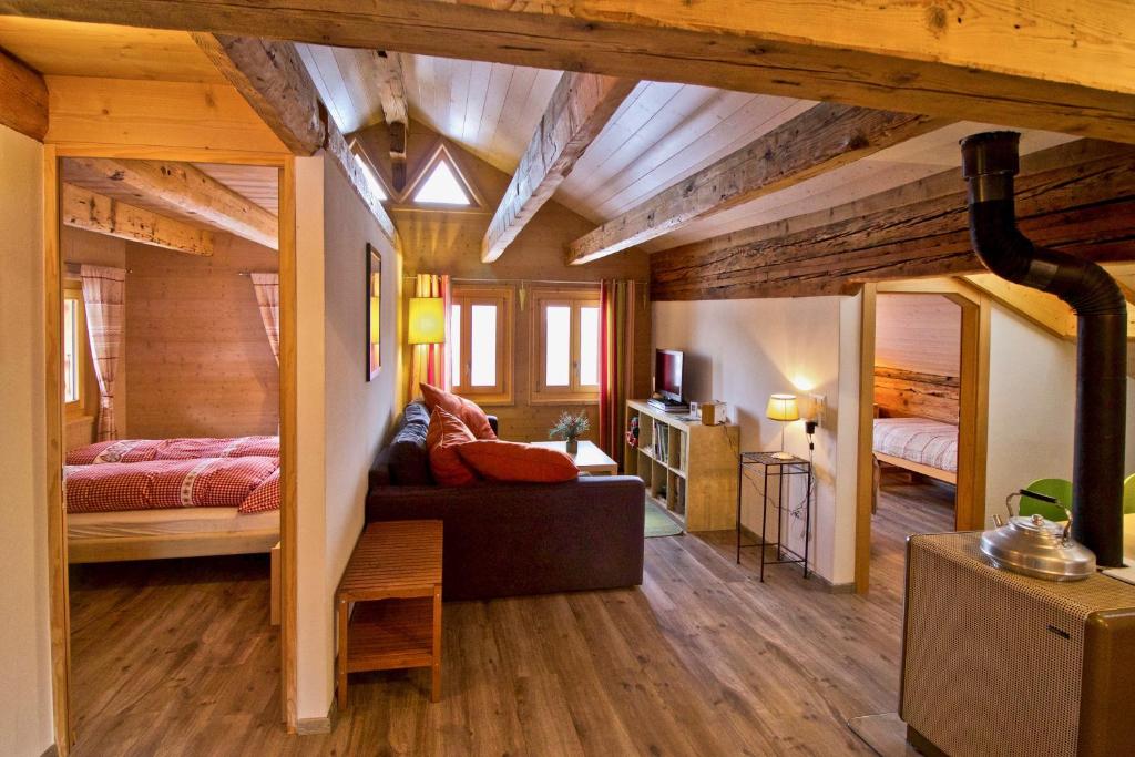 韦尔科兰Appartement sous les combles - Chalet La Biolle - Vercorin的一间卧室配有两张床,卧室内配有沙发