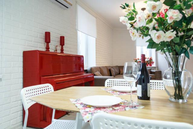 尼古拉耶夫Lotos for You Apartments 2, RED PIANO的一间带红色钢琴的餐桌的用餐室