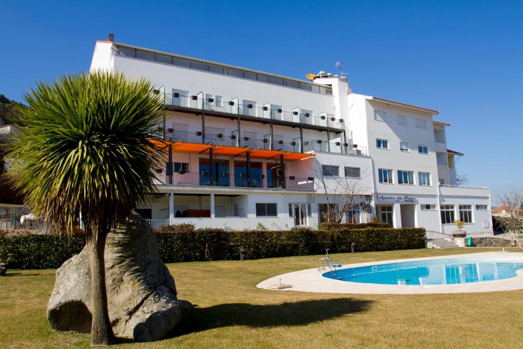 阿吉亚尔小镇阿吉亚尔佩纳酒店的一座棕榈树在游泳池前的建筑