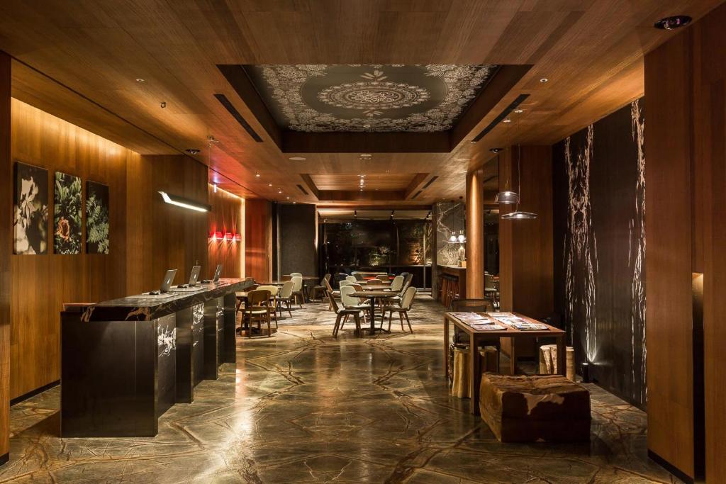 台中市薆悅酒店台中館的餐厅设有酒吧,配有桌椅