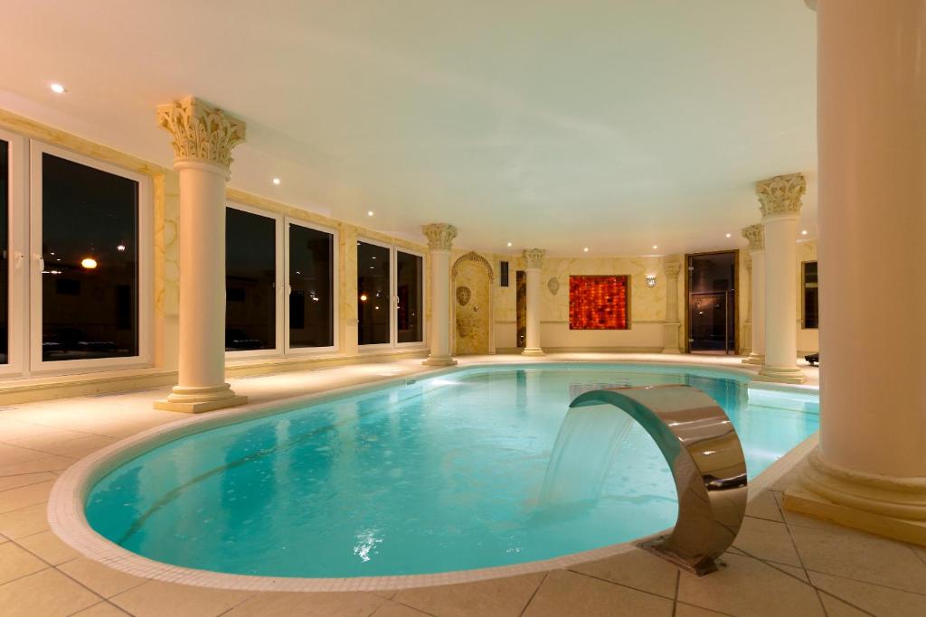 尼德布龙莱班Hôtel du Parc, Restaurant, Spa & Wellness的一座有柱子的房子里的游泳池